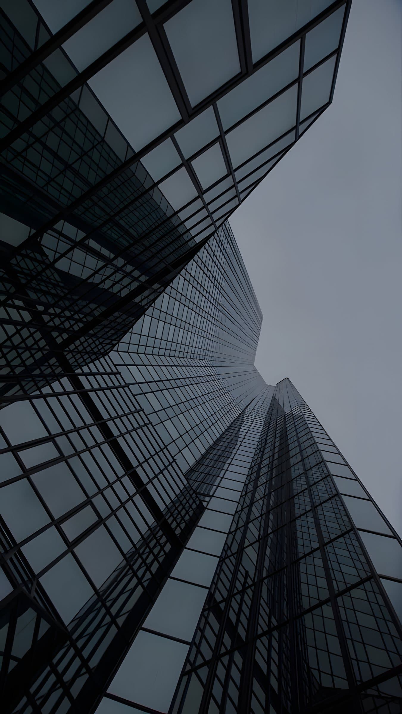 Looking up the glass facade of a tower
